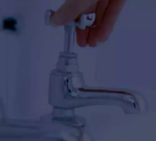Hand turning a water faucet