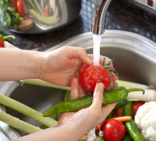 Washing vegetables under a faucet