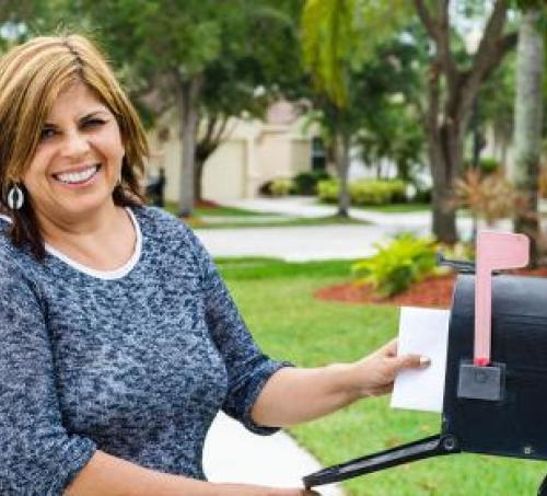 Woman checking her mailbox and smiling